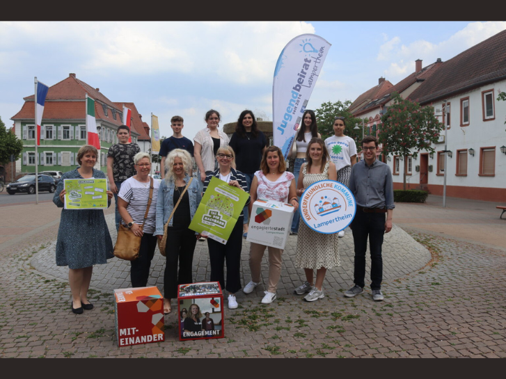 Auf dem Europaplatz stehen viele Menschen mit Plakaten zum Tag der Nachbarn 2023