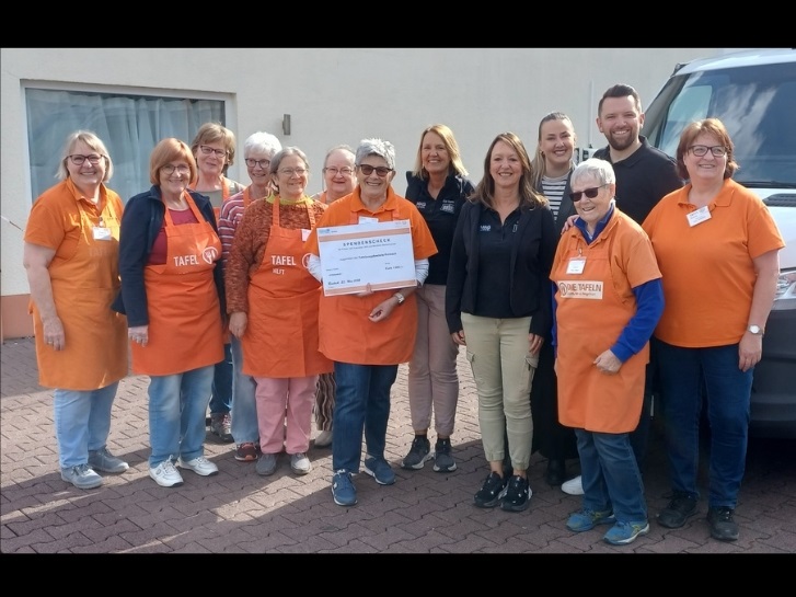 Teamleiterin Ingrid Zimoch(Mitte) nimmt stellvertretend für alle Tafel Helferinnen und Helfer die Spende von Lena Sattler & Simon Molitor (L&S Automaten – 4. v.r. und 2.v.r.) und Ute Katzenmeier & Anke Katzenmeier-Persin (BAUMAG Baufachhandel – 5. u. 6. v.r.) entgegen.