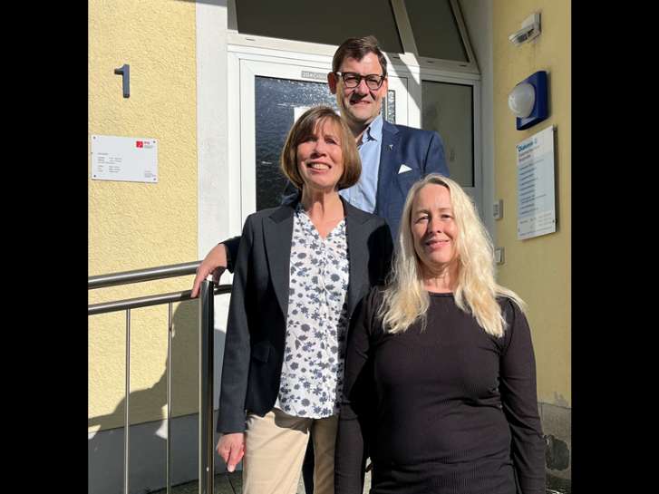 Vor dem Haus der Regionalen Diakonie in Bensheim stehen auf der Treppe vor dem Eingangsbereich Ute Weber-Schäfer und Marion Birkmeyer und im Hintergrund Dennis Kramer.