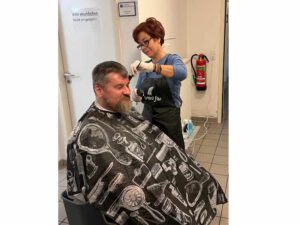 Friseurin schneidet als Ehrenamtliche einem Bewohner des Zentrums der Wohnungslosenhilfe Bensheim die Haare