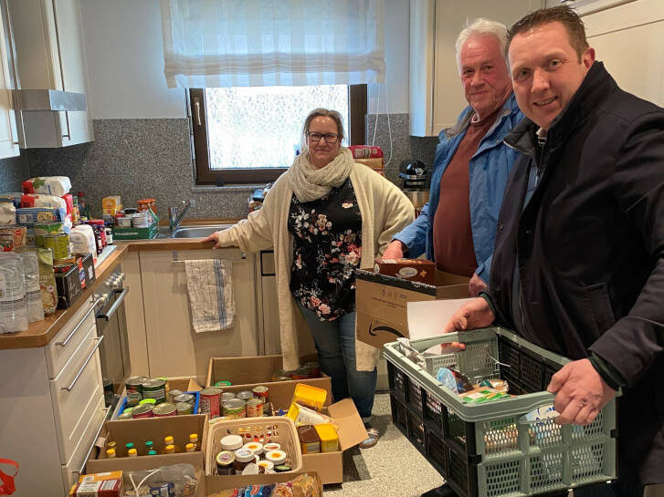 Auf dem Foto ist eine Küche voller Lebensmittel und drei Personen zu sehen: Freuen sich über die große Resonanz bei der Lebensmittel-Spendenaktion: Sandra Olf (Mitglied Kirchenvorstand Groß-Rohrheim, Organisatorin der Spendenaktion), Uwe Hartmann (ehrenamtlicher Teamleiter Fahrer & Logistik Tafel) und Volker Götz (neuer ehrenamtlicher Teamleiter Fahrer & Logistik Tafel). Foto: oh