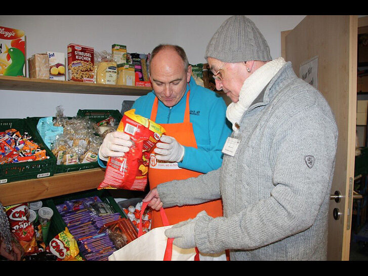 Dekan Kreh bei der Lebensmittelausgabe an Hermann Oettinger, Kunde und ehrenamtlicher Mitarbeiter der Tafel in Rimbach. Foto: bbiew